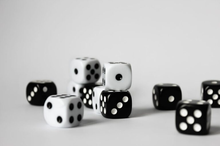 A set of black and white D6 dice stacked on a table.